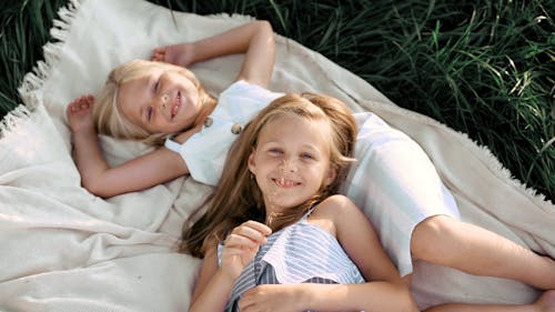 Two Pretty Girls Lying on the Picnic Blanket