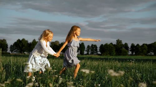 Two Girls Holding Hands while Running