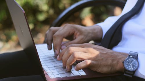 A Person Typing On A Laptop Keyboard