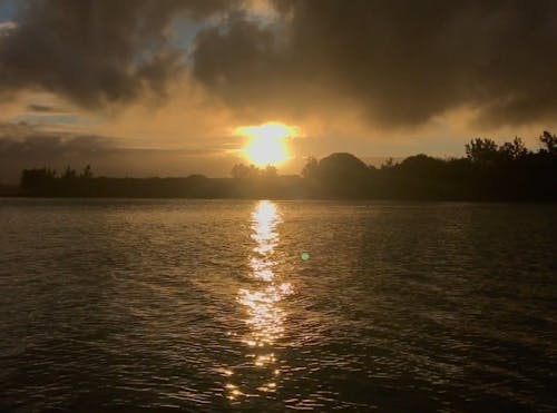 Beautiful Sunset Over Sea With Sunbeam Through Clouds