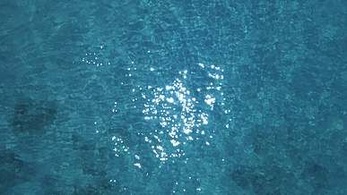 an aerial view of the ocean with a boat in the water