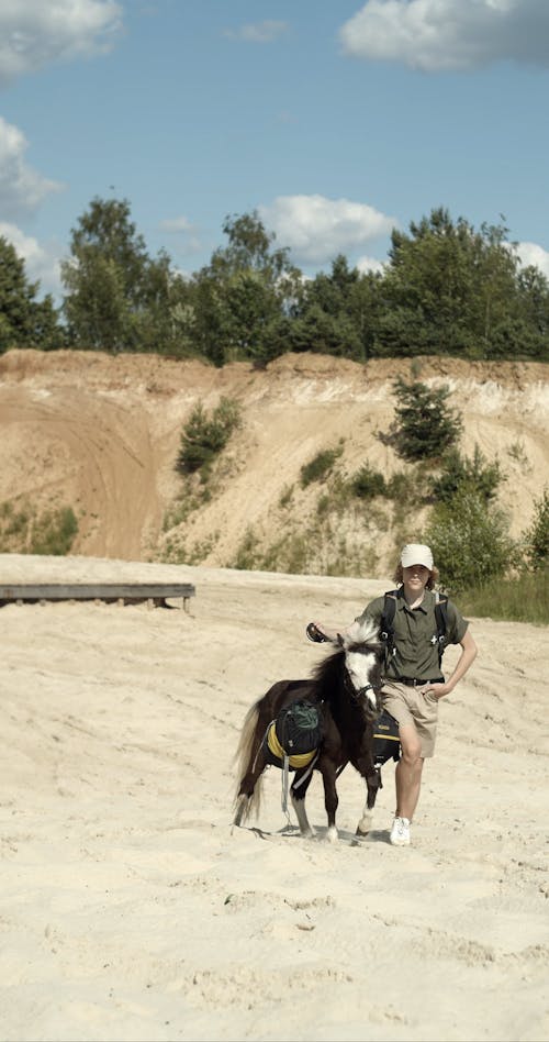 A Person Walking with a Pony