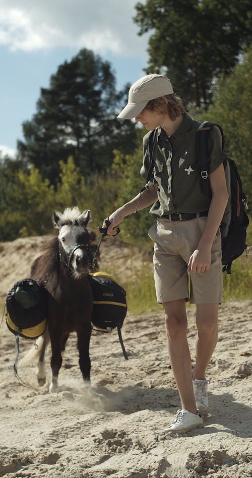 A Person Walking with a Pony