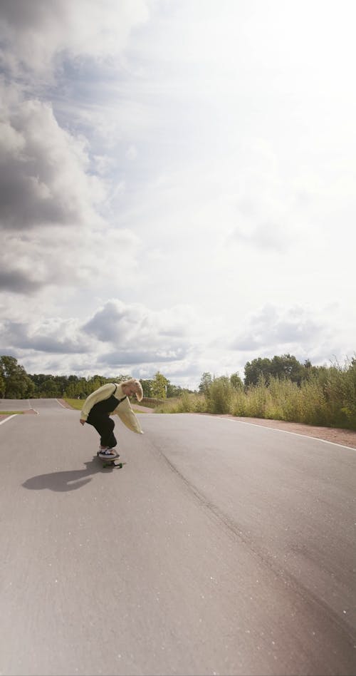 Girl in Overalls Riding a Longboard