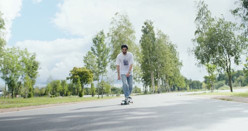 Man Ridding a Longboard on the Road