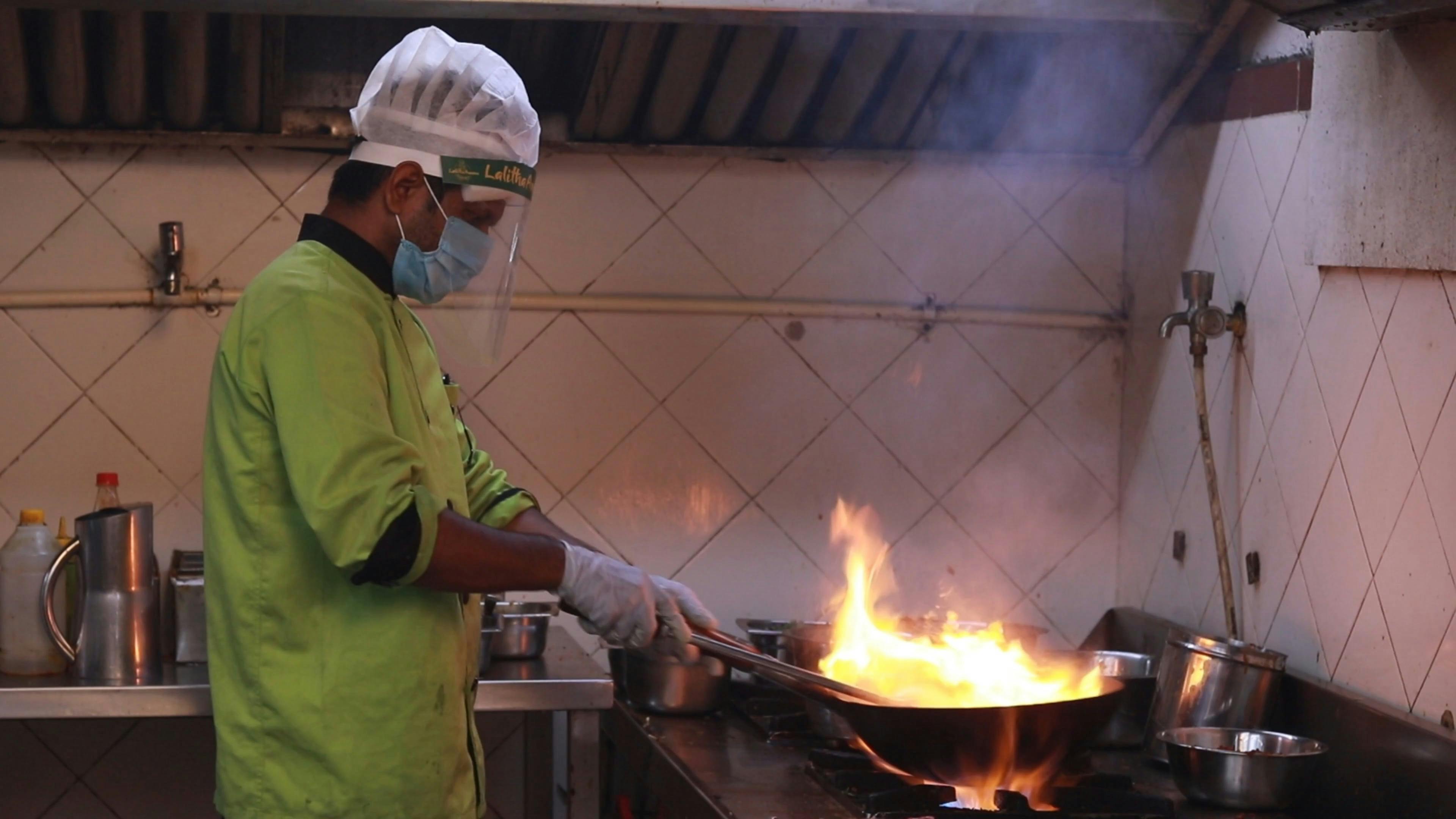 A Chef Cooking while Wearing Personal Protective Equipment · Free Stock