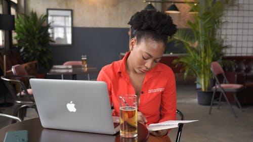 A Woman Busy Writing on a Notebook