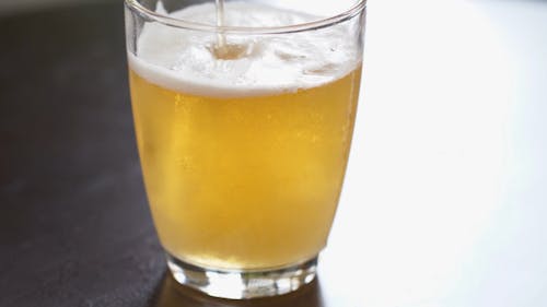 Close-Up View of Pouring a Beer into a Glass