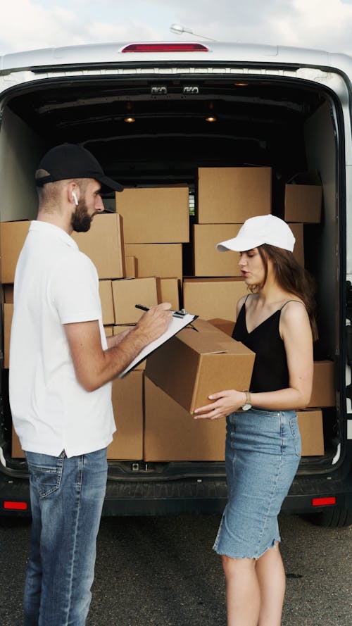 Delivery Man talking to Lady and making Checklist