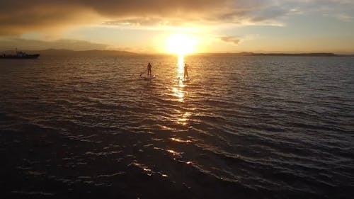 Evening Shot of Two People Rowing in the Sea