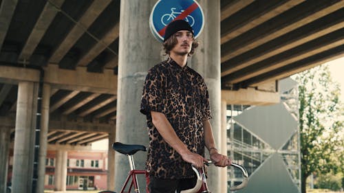 Young Guy wearing Cheetah Print Shirt with his Bicycle