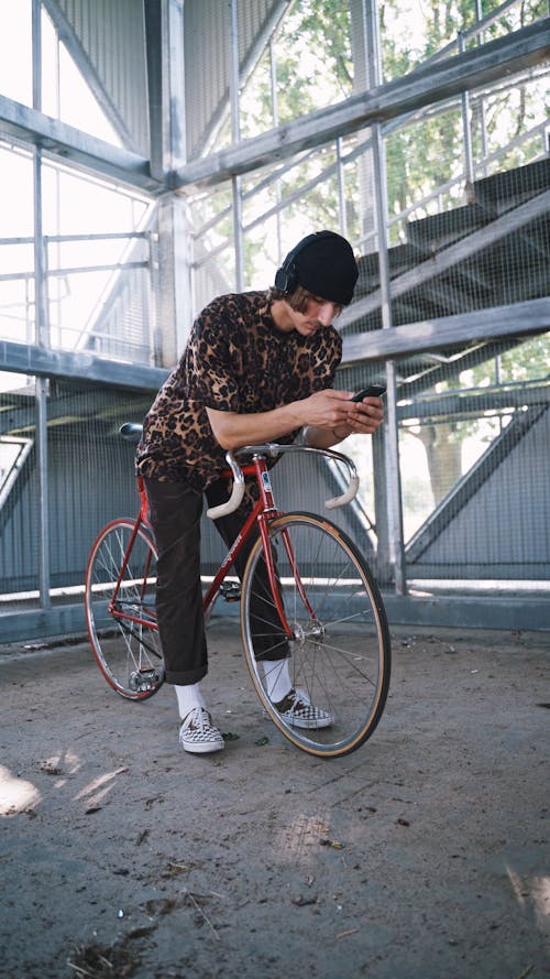 Young Guy with Bicycle using Mobile Phone