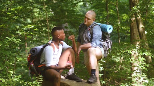 Two Backpackers Talking and Eating in Woods