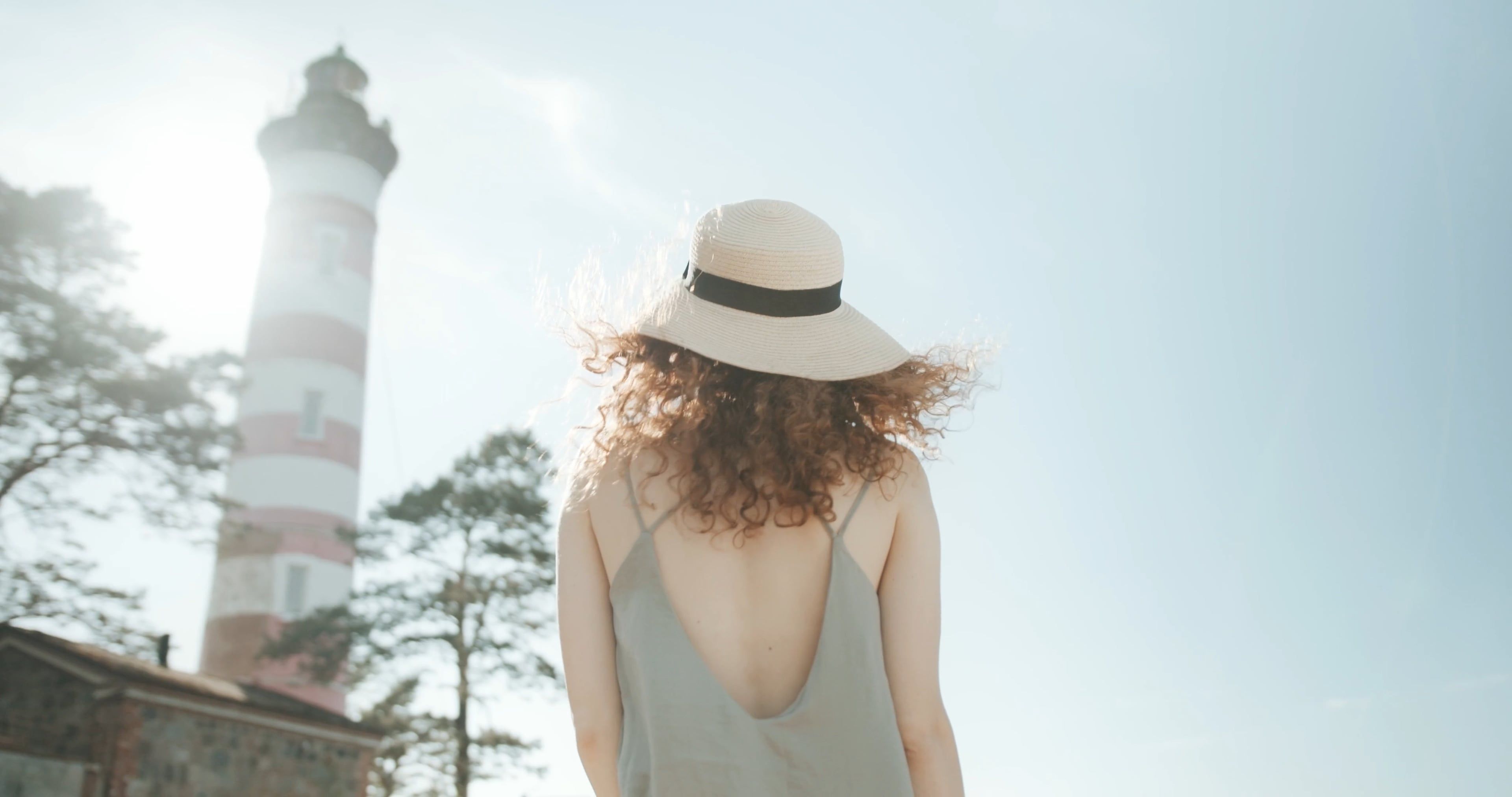 A Woman Walking Near Lighthouse During Sunny Day · Free Stock Video