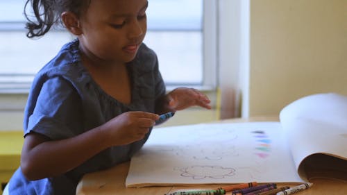 girl coloring with crayons