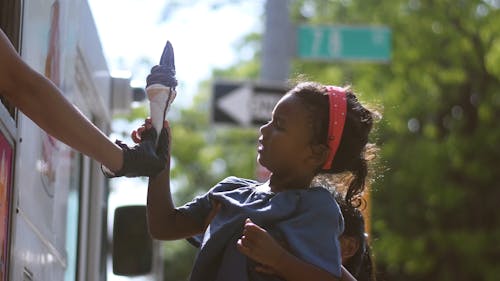 Mom Lifting Daughter up to get her an ice Cream