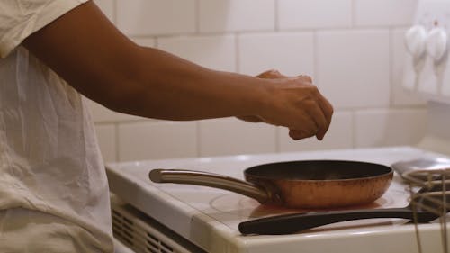 Woman Frying Eggs in Kitchen