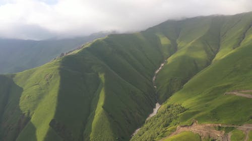 Aerial Video of River Flowing by Lush Green Mountains