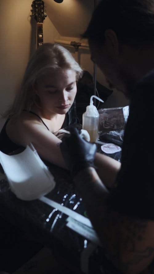 Zoom in Video Shot of a Woman Getting Tattooed