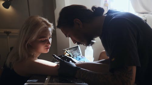 Tattooist Making Tattoo on Arm of a Beautiful Woman