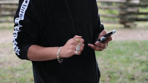 Guy in Black Hoodie Busy with his Phone