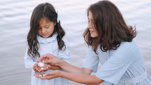 Mom and Daughter Holding Seashells