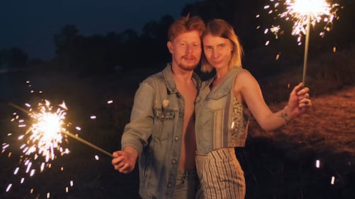 Couple Holding Two Lighted Sparklers