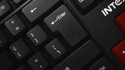 Person Pressing Enter Button of a Keyboard in Slow Motion