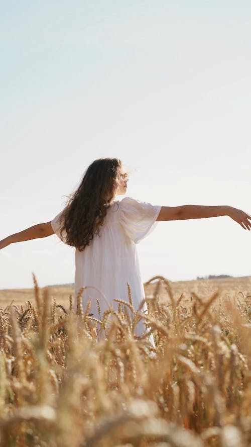 Woman with White Dress and Hands on Head in Farm