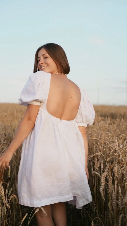 Beautiful Woman in White Dress Walking into the Wheat Fields