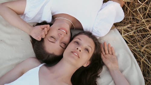 Two Young Women Lying Down with their Heads Together