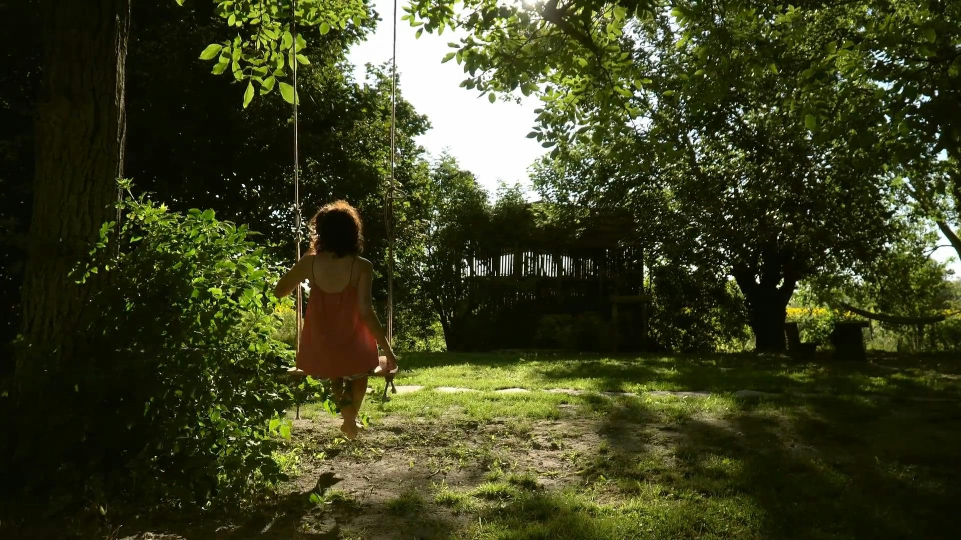 Back View of a Woman on Swing with Her Coffee · Free Stock Video