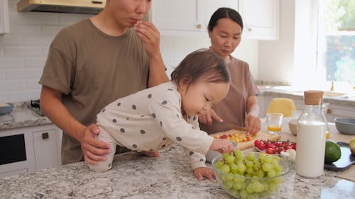 Joyful Toddler with his Parents in Kitchen