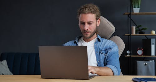 Frustrated Young Guy Yelling over his Laptop