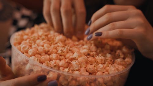 A Person Holding a Bucket of Popcorn