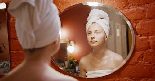 A Woman Standing In Front Of a Mirror