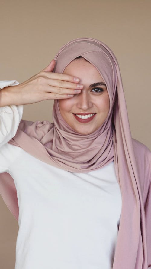 Woman in Hijab Smiling While Covering Her Eyes With Her Hands