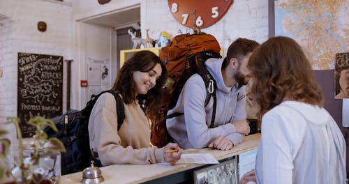 Couple Talking to a Woman in Front Desk