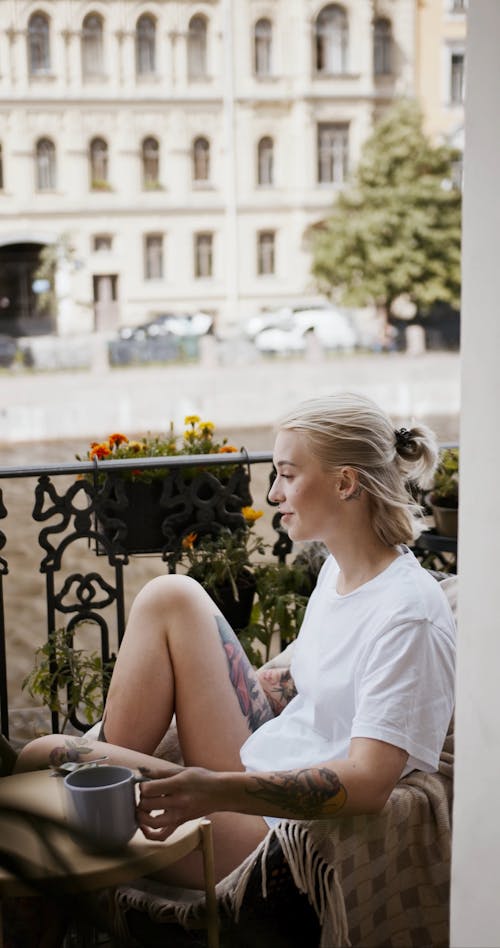 A Woman Drinking Her Coffee In The Balcony