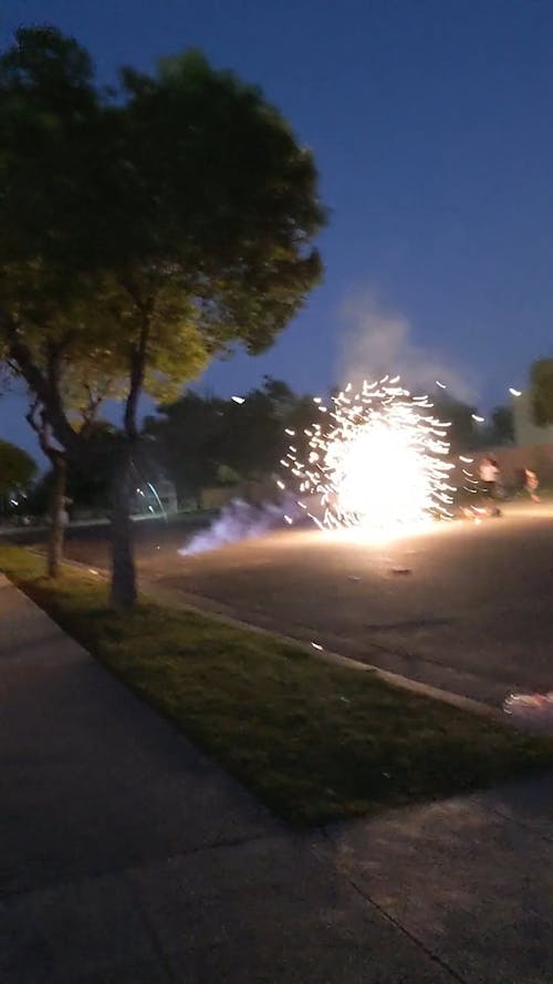 People Watching a Lighted Firecrackers on Street