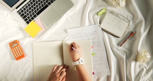 Persoon Die Op De Notebook Schrijft Terwijl Hij Op Het Bed Ligt