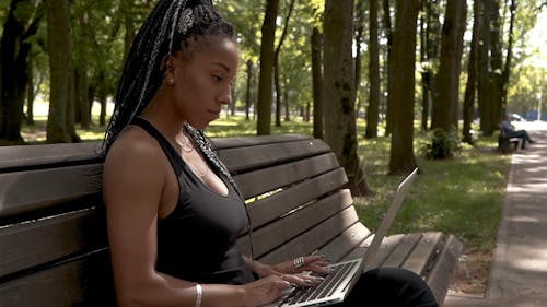 A Woman Using A laptop on A park Bench