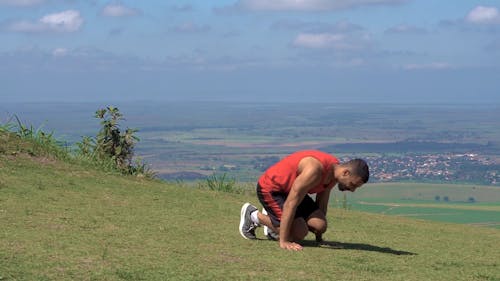 Man Doing Handstand in Grass Field