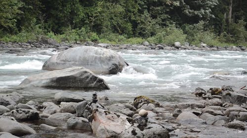 Stashing Small Rocks Over Boulders By The Riverside