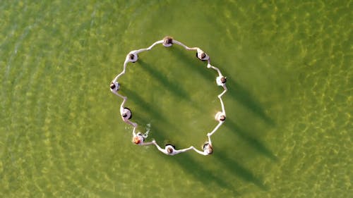 A Group of People Forming A Circle While In The Lake