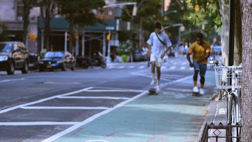 Dua Pemuda Skateboarding Di Trotoar Jalan