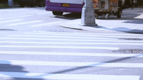 Skateboarders Crossing A Road By Walking