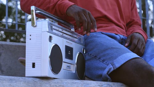 A Black Person Playing A Cassette Tape Player