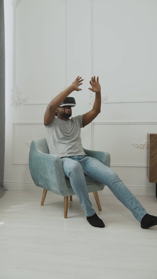 Man Sitting on Chair Feeling the Experience of VR Headset