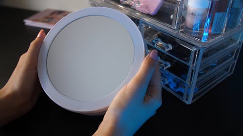 Person Holding a Round Mirror Glass